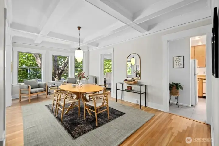 West facing windows gather light throughout the day. Note the tall ceilings punctuated with box beams.