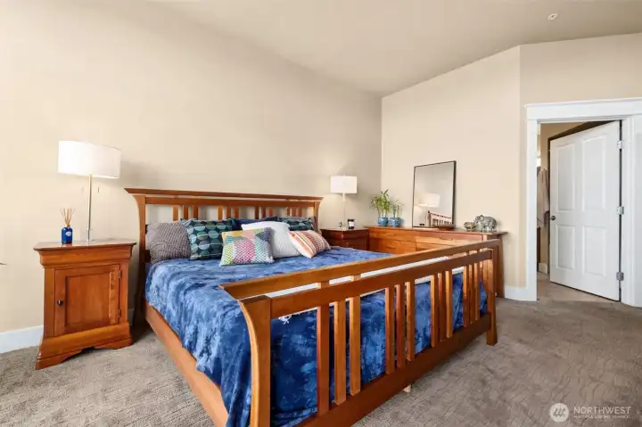 Here you are in the primary bedroom with the entry door to your bathroom shown on the right. You can see there is plenty of space all around, even with a king size bed and night stands.