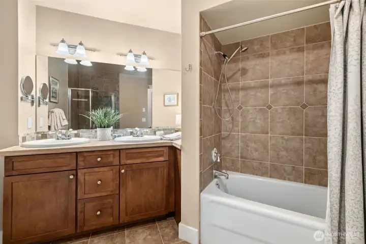 A full size porcelain bath tub features another shower in the primary bathroom.