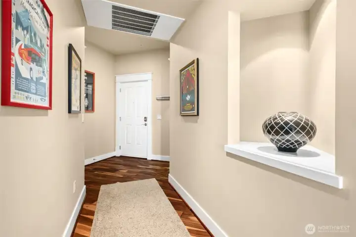 Here you are in the hallway walking toward your condo entry door. The art alcove on the right is well lit for your treasured displays.