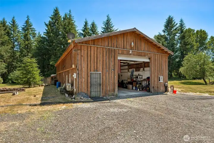 Big Shop Energy! 5 level acres of pasture & evergreens set the stage for adventure. Horses? Gardens? Hobby farm? Home business? Collector's dream shop? Bring it on! The star of the show is an incredible 2450sf  insulated shop with heat, A/C & finished bonus retreat ready to become your office, studio, lounge or favorite escape. LED lighting, automatic door, extensive work areas, overhead storage with rolling ladder & separate PSE service too! Discover fenced raised gardens, greenhouse shed, chicken run, firepit, walking trails & RV or boat parking for all the toys. A mature orchard with fresh pears, peaches, apples, figs, olives, citrus, plums, filberts & more can become part of your everyday routine. Wood laminate floors, pellet stove & circular layout leads to oak cabinetry, breakfast bar, 2 ovens & generous pantry space in bright kitchen. Huge flex room with private entrance opens exciting options for multigenerational living or mega family room. TWO primary suites! Main floor AND u