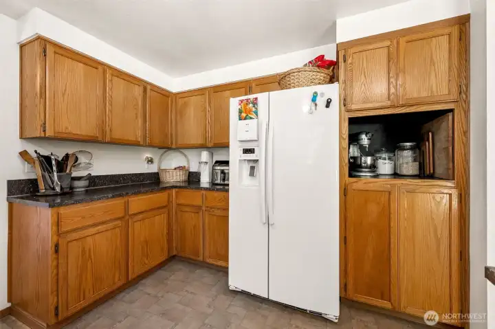 Every serious cook knows that great kitchens aren't just about appliances, they're about workflow. This side of the kitchen showcases a wonderfully functional setup with extensive pantry storage, additional cabinetry, and a dedicated appliance station that helps keep countertops clear and organized. The French door refrigerator with water and ice service adds convenience, while the layout naturally creates separate prep areas that work beautifully for households where more than one person likes to cook. One person can be working at the peninsula while another handles meal prep or cleanup without feeling crowded.