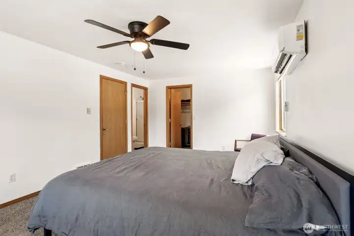 The bedroom entrance is conveniently located to one side, while the private en suite bathroom and walk-in closet each have their own dedicated entrances, creating an efficient and comfortable primary suite design. The long, spacious layout is one of this room's biggest advantages, easily accommodating a king-size bed along with multiple dressers, nightstands, and even a reading nook or sitting area without feeling crowded.
