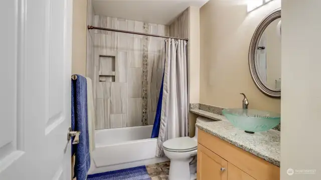 The full hall bath has also had a recent update.  Featuring a granite countertop with a glass pedestal sink.  Luxury vinyl and new slab tile modernizing the bath.