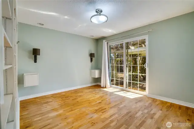 Primary suite has newer sliding door with stoop to backyard and arbor that is draped with Wisteria.