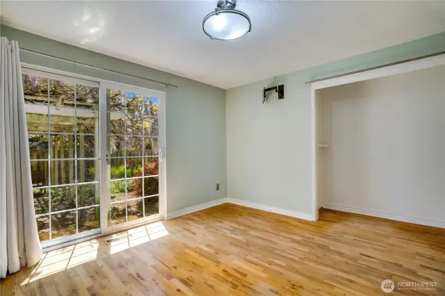 View of primary closet and sliding doors to backyard.