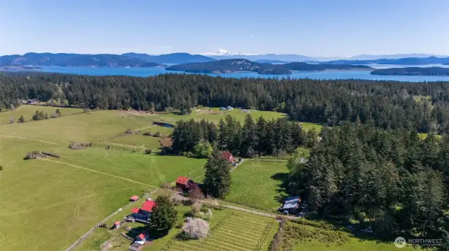 Aerial looking east toward Mt Baker. Twenty acres, multiple residences, barns, and outbuildings, pasture, forest, ponds, and territorial views in all directions