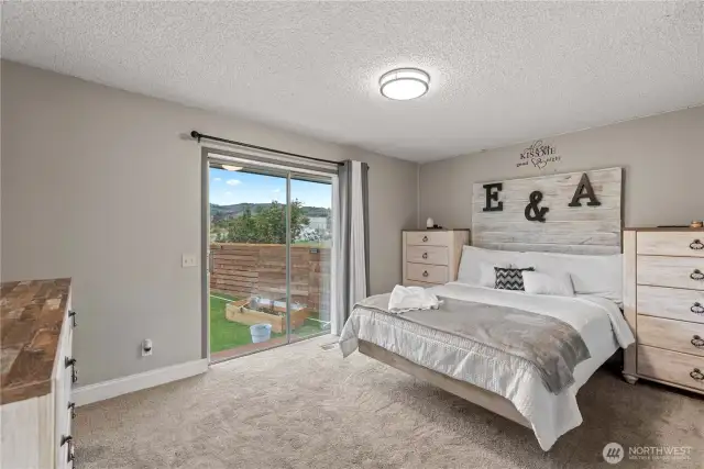 Primary bedroom with sliding door to small deck.