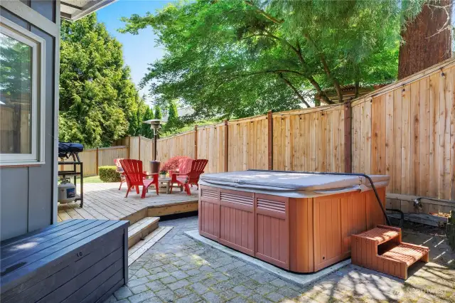 Side yard with deck and hot tub.