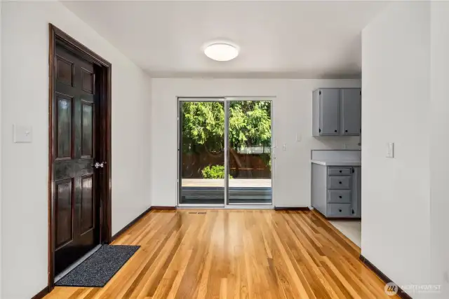 Bright dining area with refinished hardwood floors and direct access to the backyard through large sliding glass doors. The seamless indoor-outdoor connection makes it easy to entertain, while natural light highlights the clean, neutral finishes.