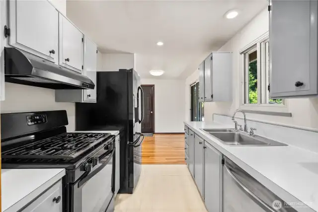 Classic galley design with ample storage and direct sightlines to the dining area and backyard. Neutral finishes make this space move-in ready and easy to customize with your own style.