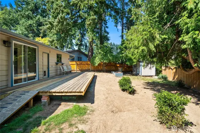 Private backyard with a mix of open space and shade from mature trees, offering plenty of room for pets, play, or gardening.