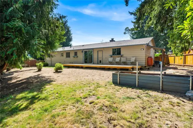 Backyard perspective highlighting the large deck and seating area—an ideal setup for barbecues, gatherings, or quiet evenings at home.