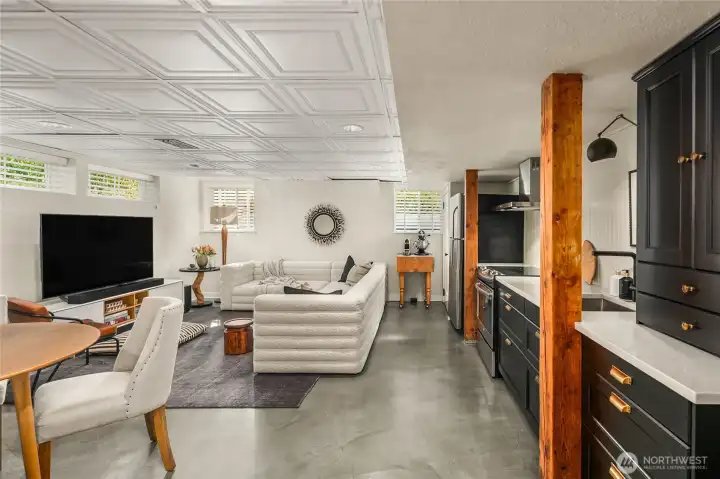 The lower level ADU combines a spacious living area with a modern kitchen featuring quartz counters, custom cabinetry, and stainless steel appliances. Warm wood beams and polished concrete floors add character and durability. Heated floors in front of kitchen area!