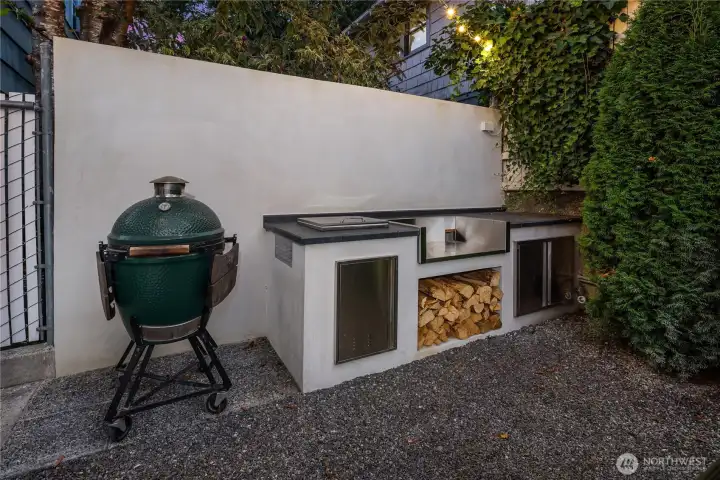 An entertainer’s dream, the outdoor kitchen features wood storage and stainless-steel cabinetry—all designed for year-round cooking and gathering. *Plumbed for a 32" gas grill!!*