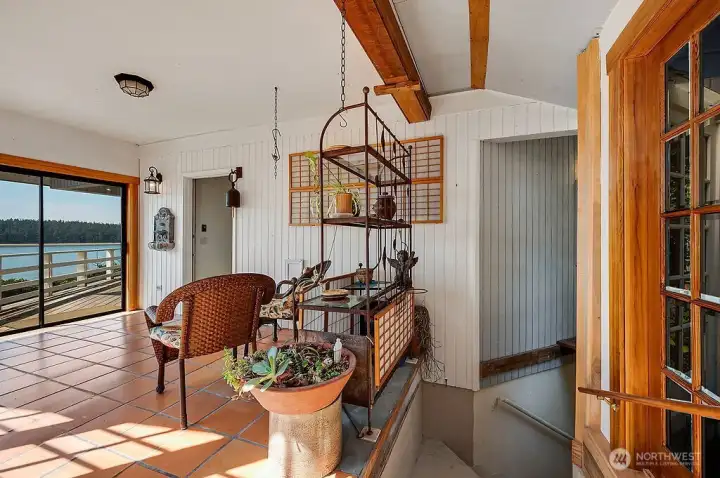 Sunroom with stairs down to basement.