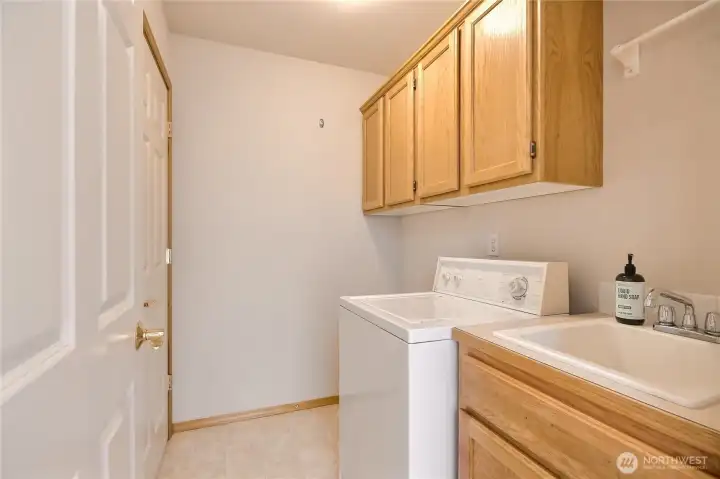 Laundry room with sink and storage.