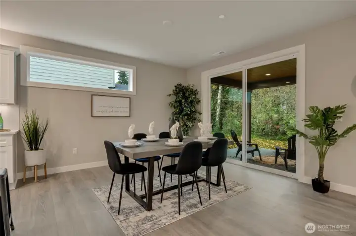 A stunning dining room seamlessly extends to a covered back deck through a sleek sliding door, perfect for indoor-outdoor entertaining or serene alfresco meals.