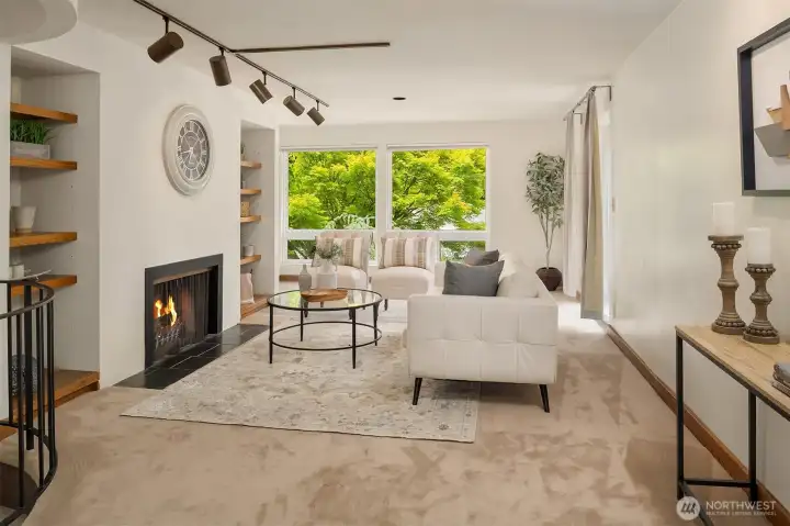 Living Room with fireplace, flanked by built-in shelves, an abundance of windows for sun-filled space.