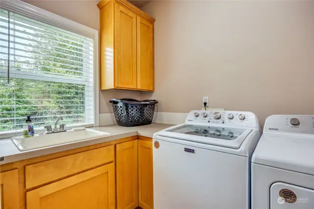 Laundry room has deep sink, great storage and counter for folding your laundry.