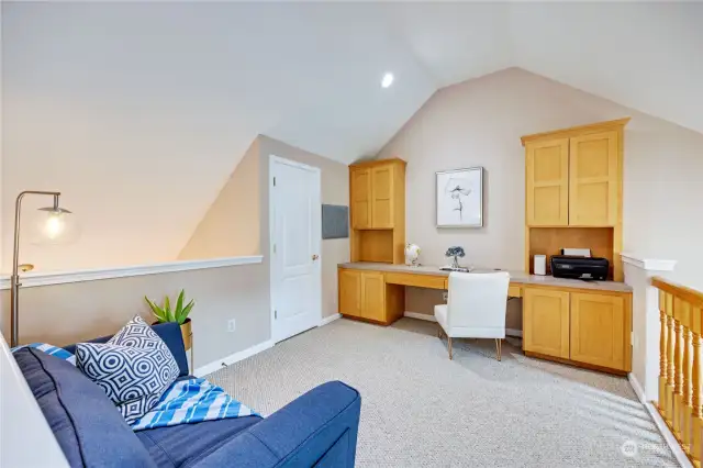 Loft with storage closet and built-in office.