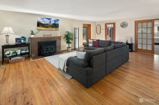 Spacious main living room with wood-burning fireplace & original hardwood floors welcome you into this home.
