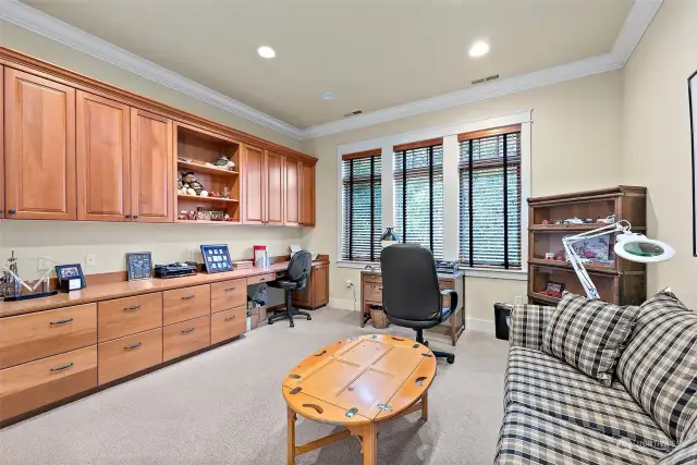 The spacious den includes custom-built cabinets and a desk.