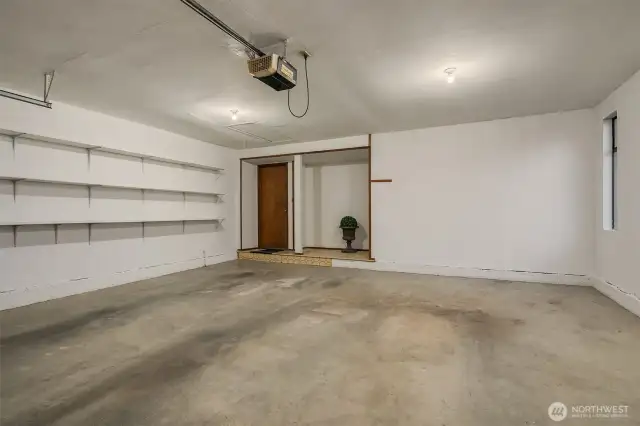 Ample 2 car garage with storage shelves and storage area.