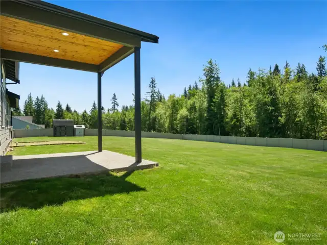 Back patio is covered and perfect for barbeques. Look at that huge fenced backyard! That fence is high quality and over 5' tall.
