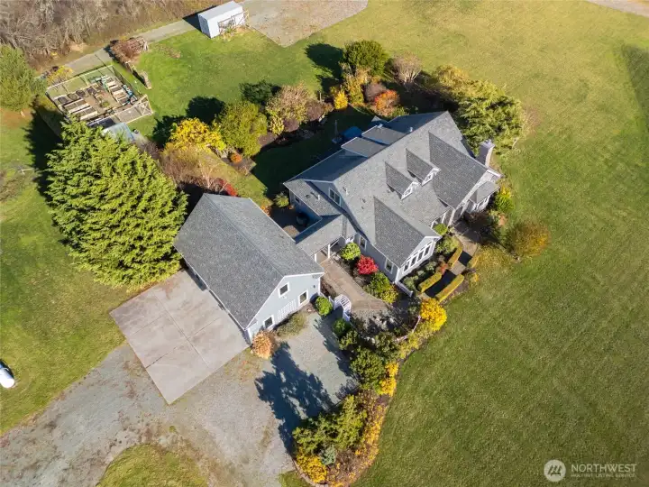 Hops trellises and two young apple trees sit adjacent to the container, adding beauty and future fruit production.