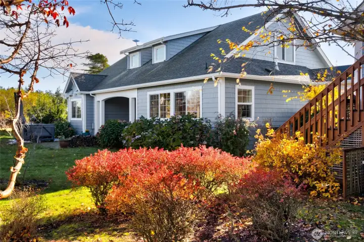 The hydrangea, fuchsia, and lilac garden sits beside a patio area directly behind the house, featuring a new HighLife Jet Setter hot tub still under warranty—perfect for evening relaxation and stargazing.