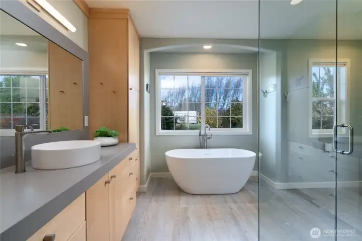 Beautiful primary ensuite bathroom with a glass/concrete shower and a slipper bathtub.