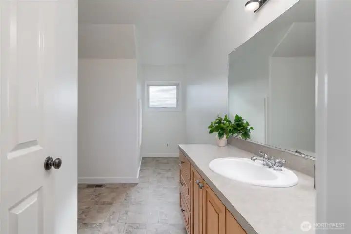 Second-floor full bathroom positioned beside a spacious supply closet for added storage.