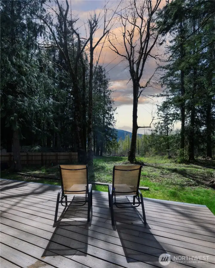 On the deck, lounge chairs sit facing the river, creating an ideal spot to relax and soak in the tranquil scenery.