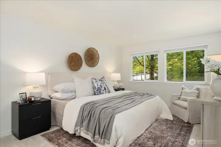 Large windows in the primary suite offer a peaceful view of the backyard.