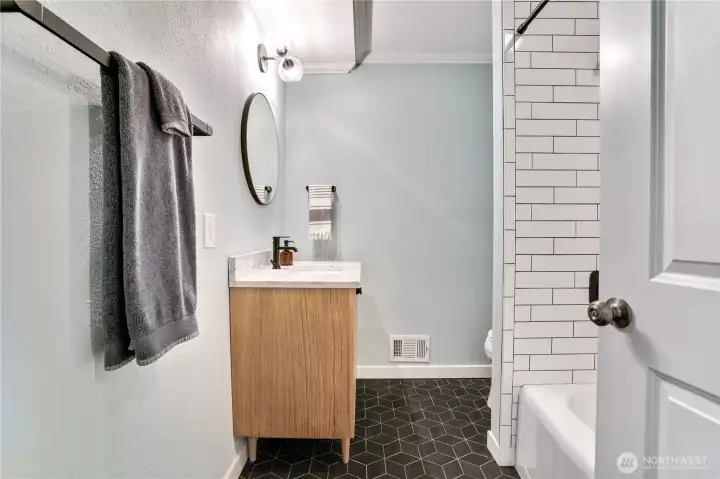 Stylishly updated, this hall bath features custom tile finishes and a relaxing soaking tub designed for comfort and everyday luxury.
