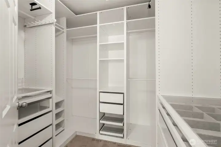 Primary walk in closet with custom organizers