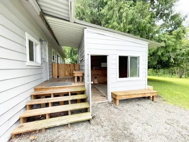 Back of home with covered porch and storage shed.