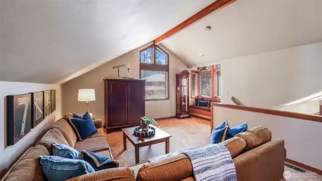 Spacious loft with vaulted ceilings and a cozy window seat.