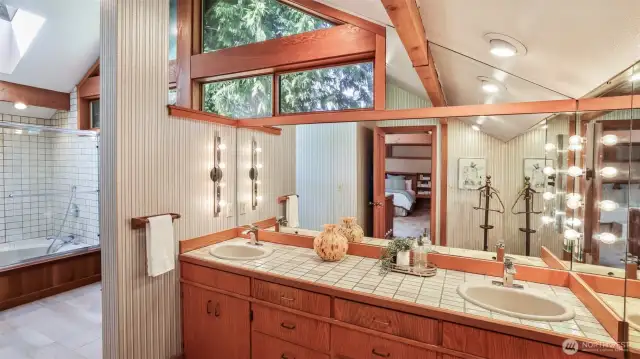 Not your standard bathroom. A soaking tub, dual vanities, vaulted ceiling, and wood framed windows extend the refined charm found throughout the home.