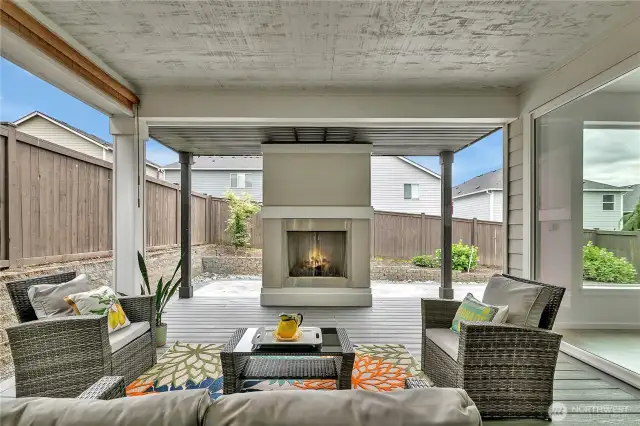 Relax on the covered outdoor living room year-round. With the flip of a switch, enjoy a gas fire in the fireplace.