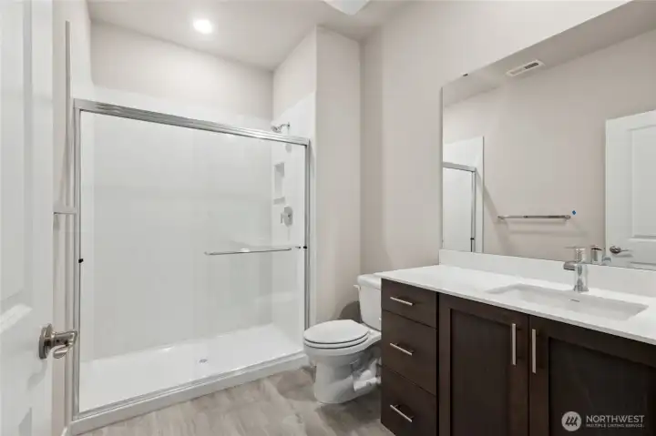 Bedroom 3 bathroom with stand up shower and glass surround. Photo rendering is representational. Actual home is under construction and finishes, elevation, and paint colors may vary. See site agent for details.