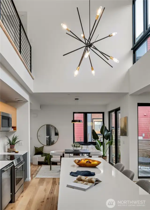 The kitchen boasts impressive double-height ceilings and features a generous island, creating a stunning focal point and providing ample space for culinary activities.