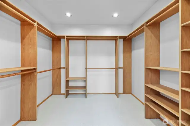 Walk-in primary closet with built-in ironing board.