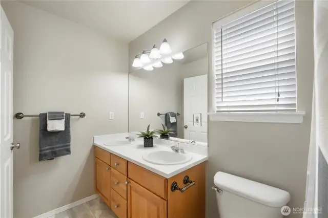 Upstairs second full bath w/two sinks, tub/shower combo.