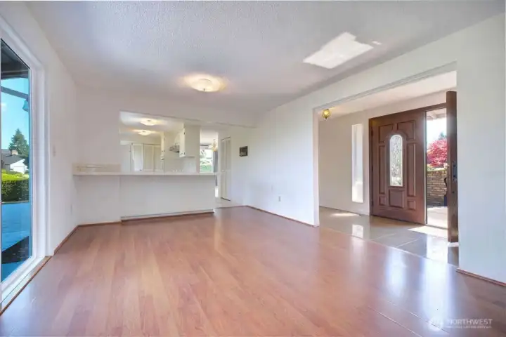 Laminate Floors leading the oversized sliding door to the back patio and to the L-shaped kitchen