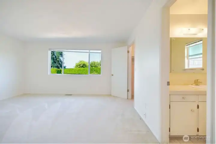 Primary bedroom with west facing window and walk in closet and primary bath with shower