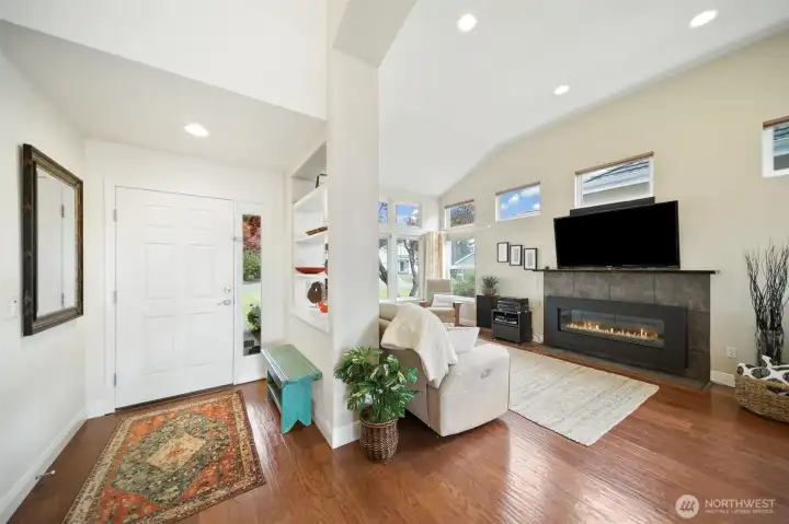 The welcoming living area features lofty ceilings, a cozy gas fireplace, and a spacious, open ambiance.