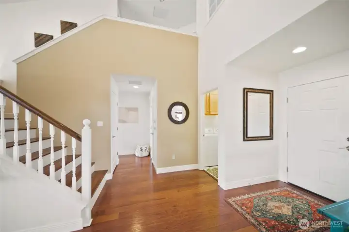 Step back inside to discover the other wing of the main level, where convenient laundry and two-car garage access lie to the right, and the luxurious primary bedroom awaits to the left.