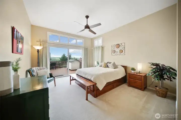 The spacious main floor primary suite provides direct access to the expansive back deck with stunning views and features lofty cathedral ceilings.